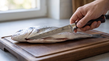 Fileermes fileert een rondvis plat langs de ruggengraat